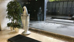 A bench, a potted plant, and a water fountain in a lobby area. - Kashiwa Plaza Hotel (Kashiwa)