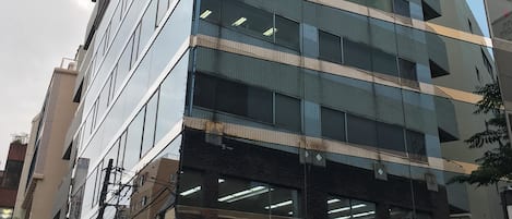 Un moderno edificio de hotel con fachada de vidrio y señalización para Kashiwa Plaza Hotel.