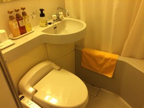 Kylpyhuoneessa on wc, pesuallas ja kylpyamme. Pesualtaan reunalla on hygieniatuotteita.