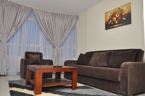 Suite Familiale, coin cuisine, vue ville | Salle de séjour | Télévision à écran plat