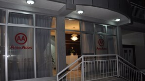 A building entrance with glass doors displaying the logo "AA" and the name "AFRO ADIS". - Afroaddis Hotel Apartment (Addis Ababa)