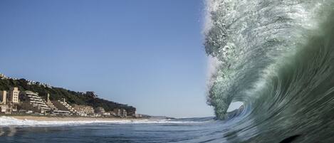 Una playa cerca, sillas reclinables de playa, sombrillas