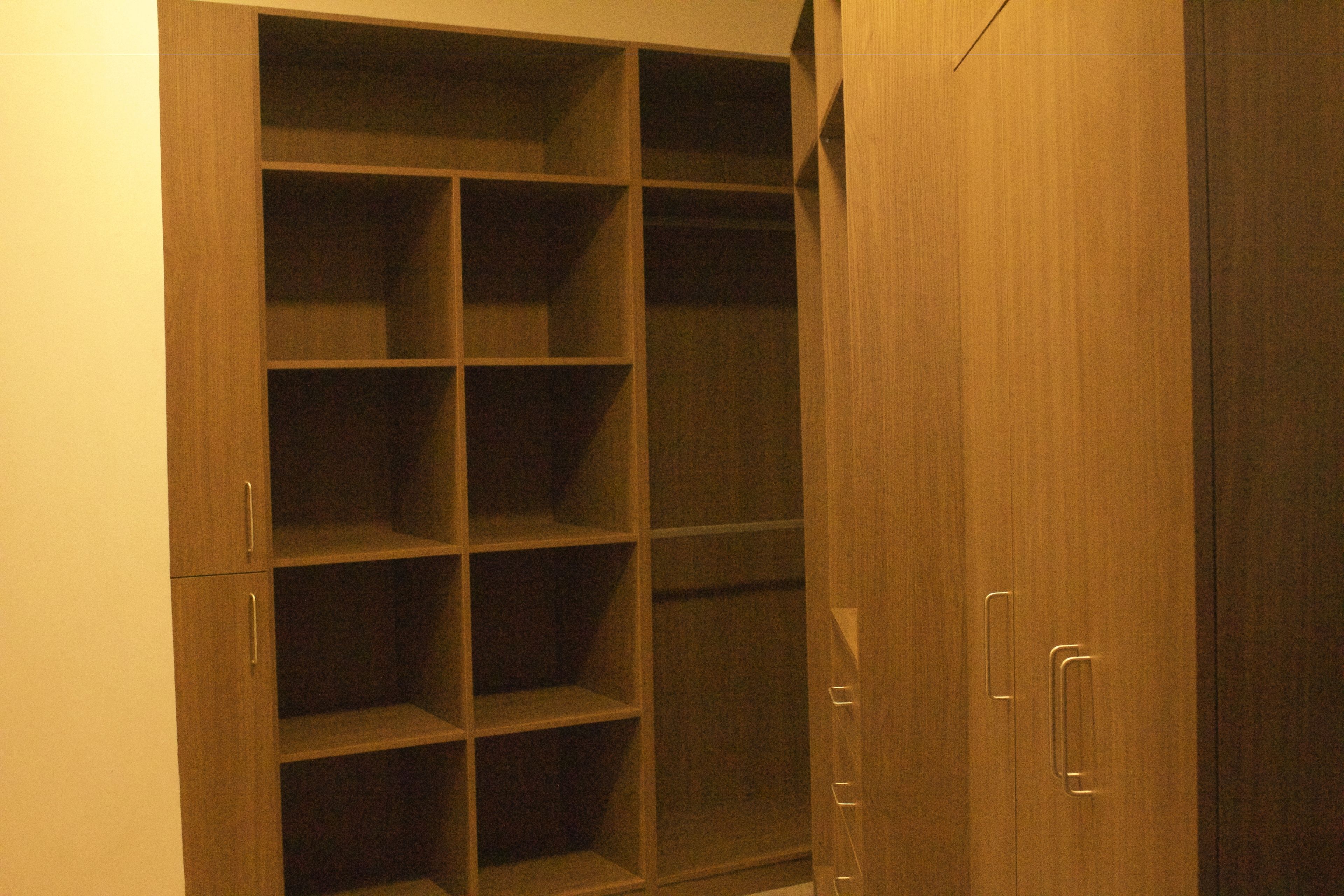 A wooden wardrobe with multiple shelves and drawers.