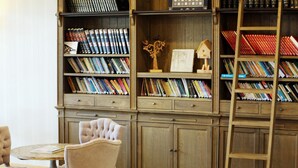 Una biblioteca con estanterías, una escalera y una silla.