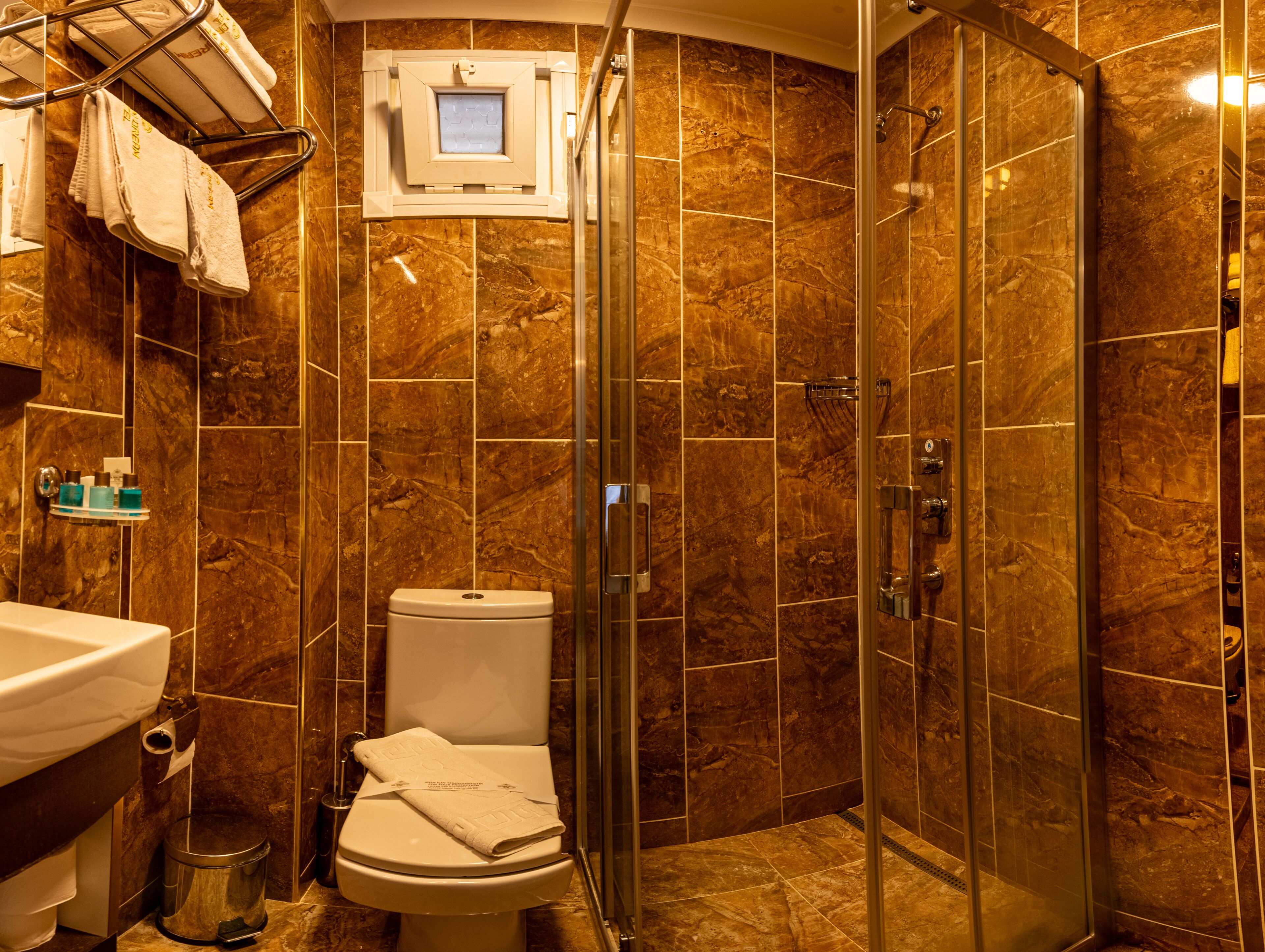 A bathroom with a toilet, sink, and shower area.