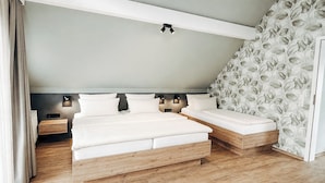 A bedroom with a bed, bedside tables, and a wall-mounted light fixture. - Hotel Garni Bergblick (Biberach)