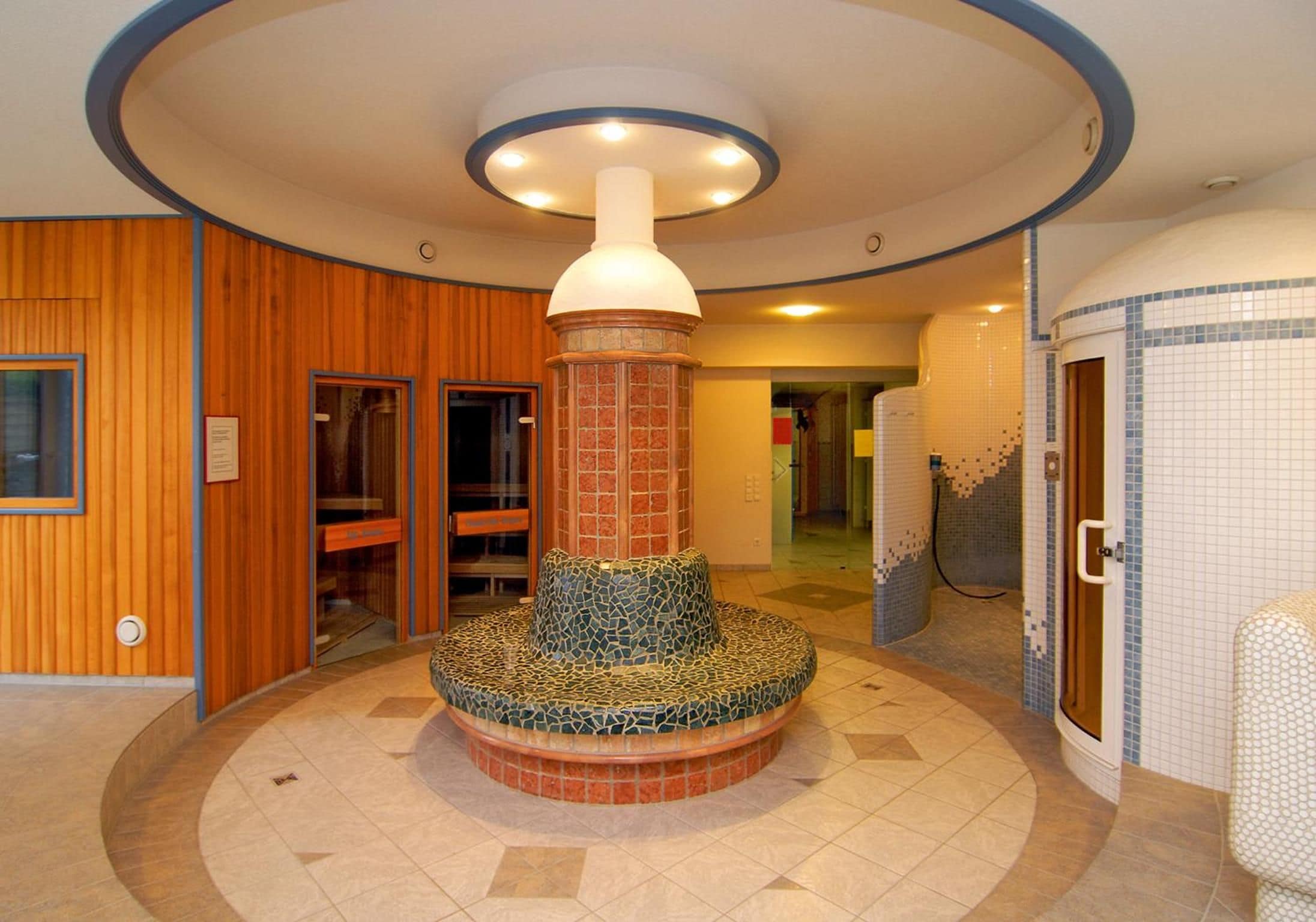 A circular seating area with a central pillar, wooden paneling on the walls, and a tiled floor.