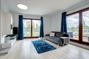 Deluxe appartement, uitzicht op rivier (with garden, 4 adults) | Woonkamer | Een 32-inch flatscreentelevisie met kabelzenders en een televisie