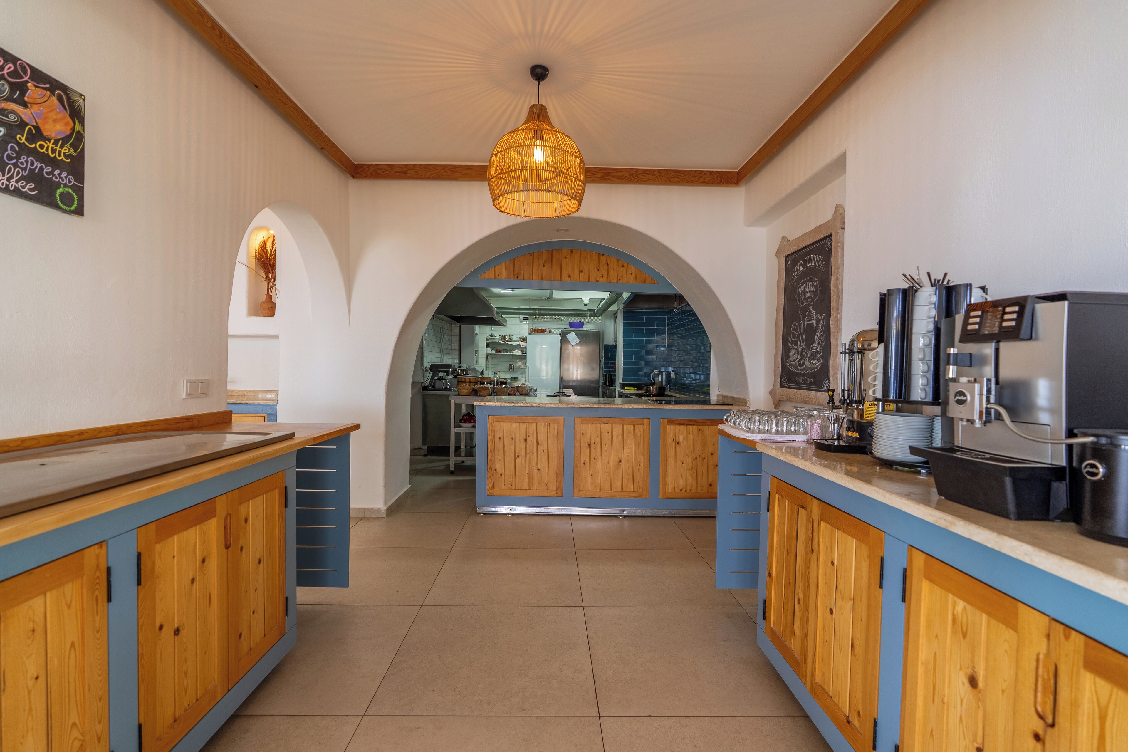 Une cuisine avec des meubles en bois, un îlot central et une machine à café.