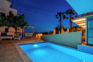 Una piscina al aire libre de temporada, sombrillas, tumbonas