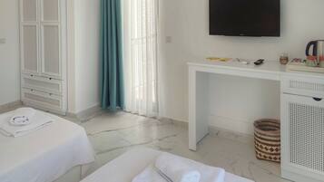 Una habitación de hotel con cama, escritorio, televisión y armario.