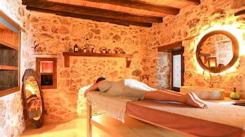 Cozy retreat with a bed, wooden bench, and round mirror.