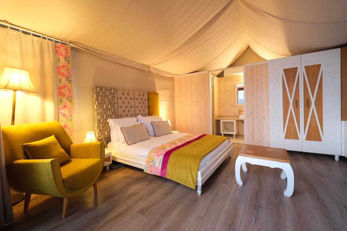 Un dormitorio con cama, mesita de noche, silla y armario.