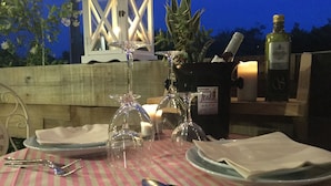 A table set for two with plates, cutlery, and a bottle of olive oil. - Albergo Trattoria Italia (Desenzano del Garda)