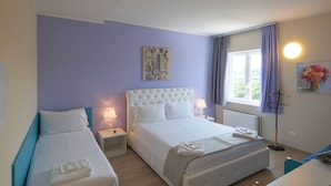 A hotel room with two beds, a large window with curtains, a wall-mounted artwork, and a bedside lamp. - Albergo Trattoria Italia (Desenzano del Garda)