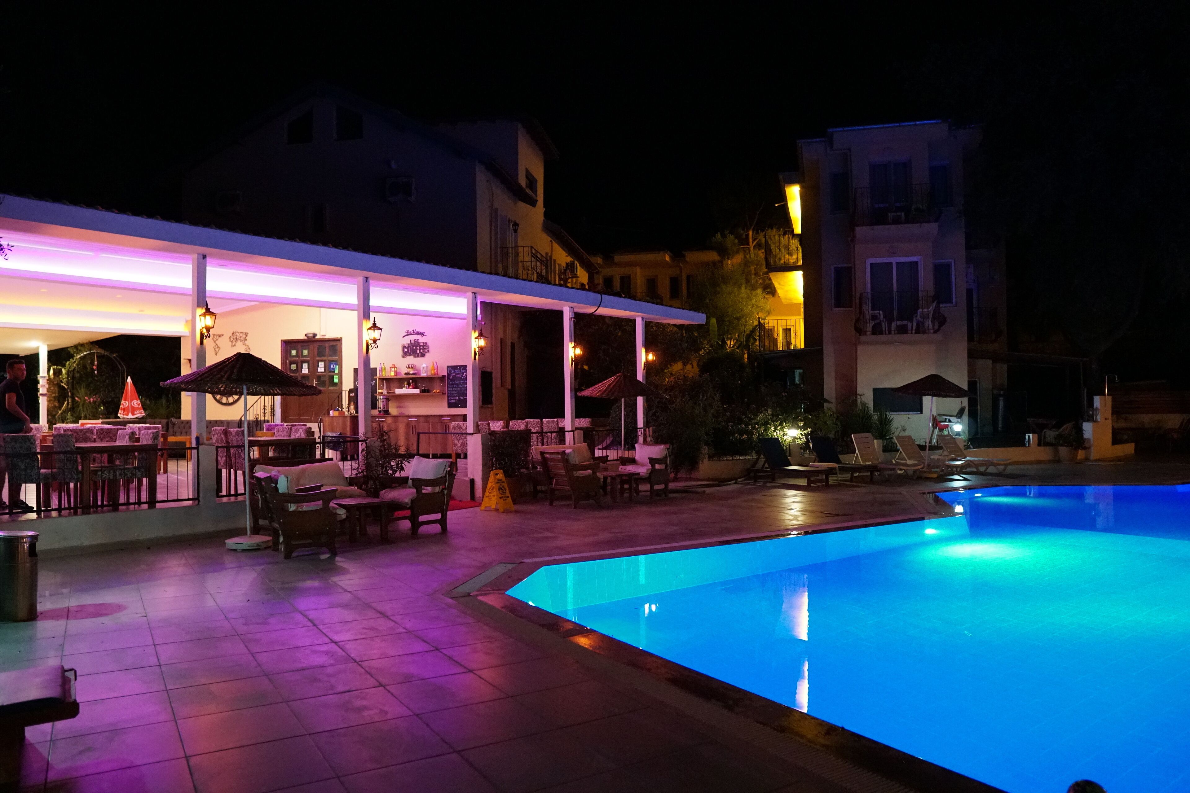 A nighttime poolside area with a bar and outdoor seating.