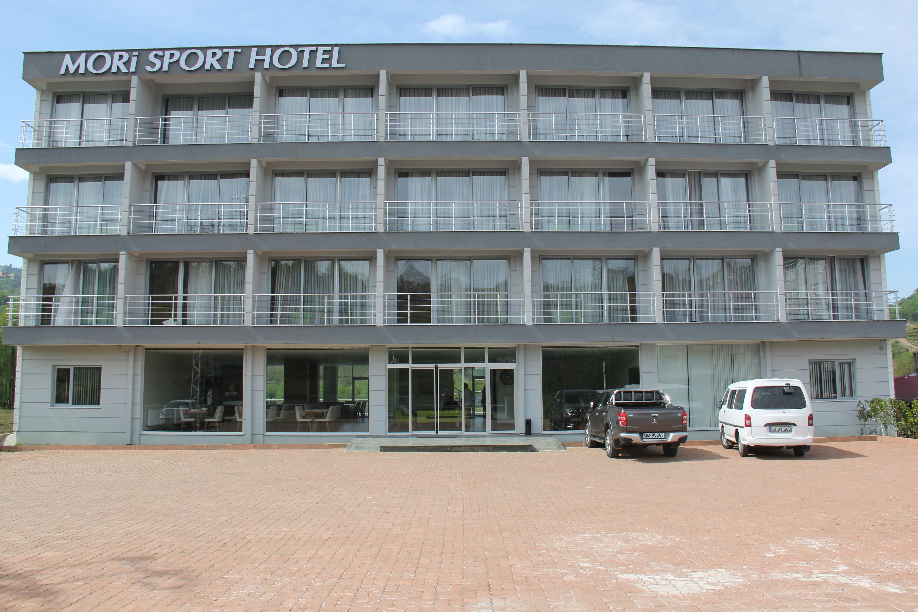 A multi-story hotel with a sign reading "Mori Sport Hotel".