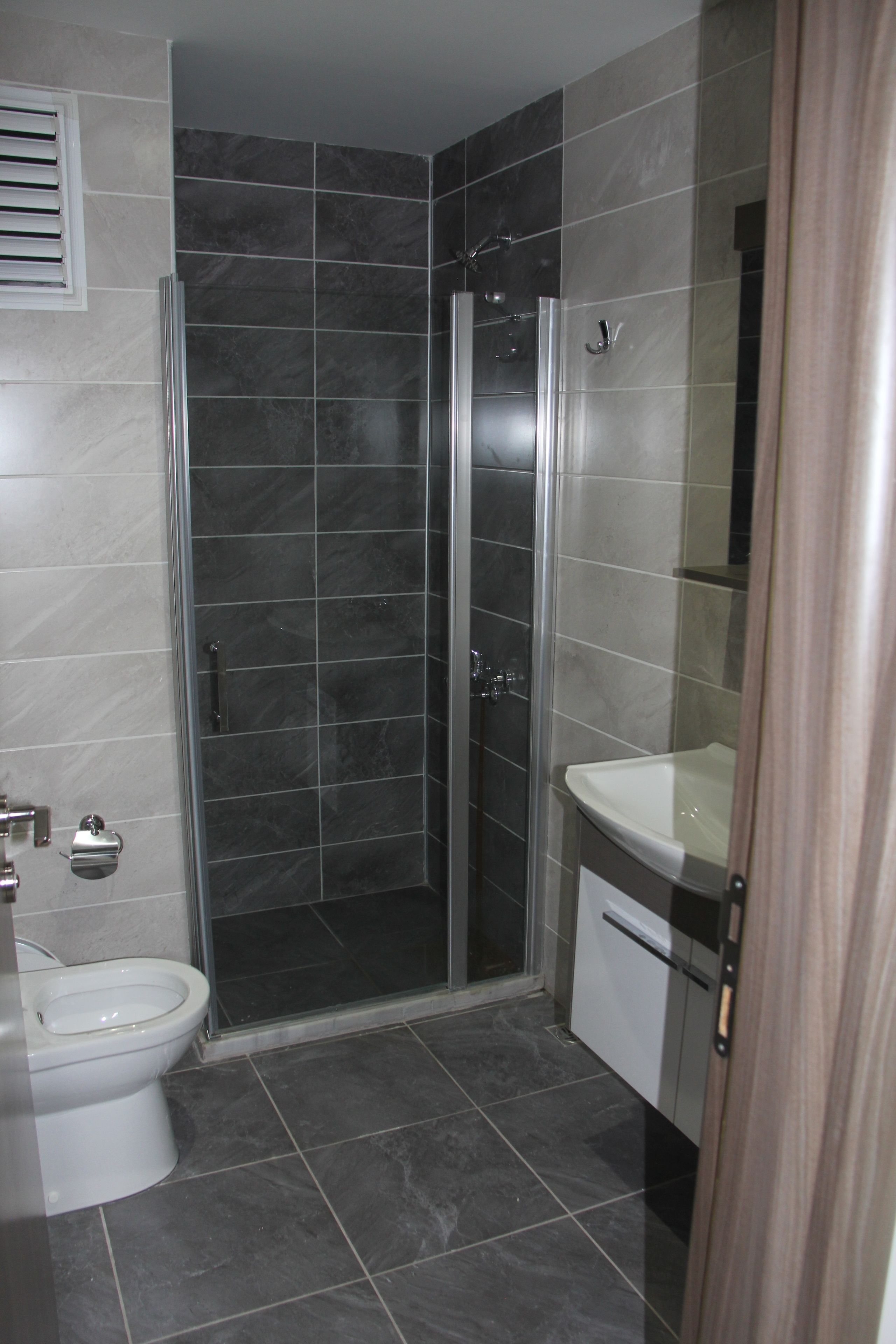 Un baño con ducha, inodoro y lavabo.