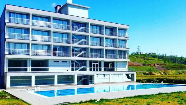 Un edificio moderno de varios pisos con una piscina delantera.