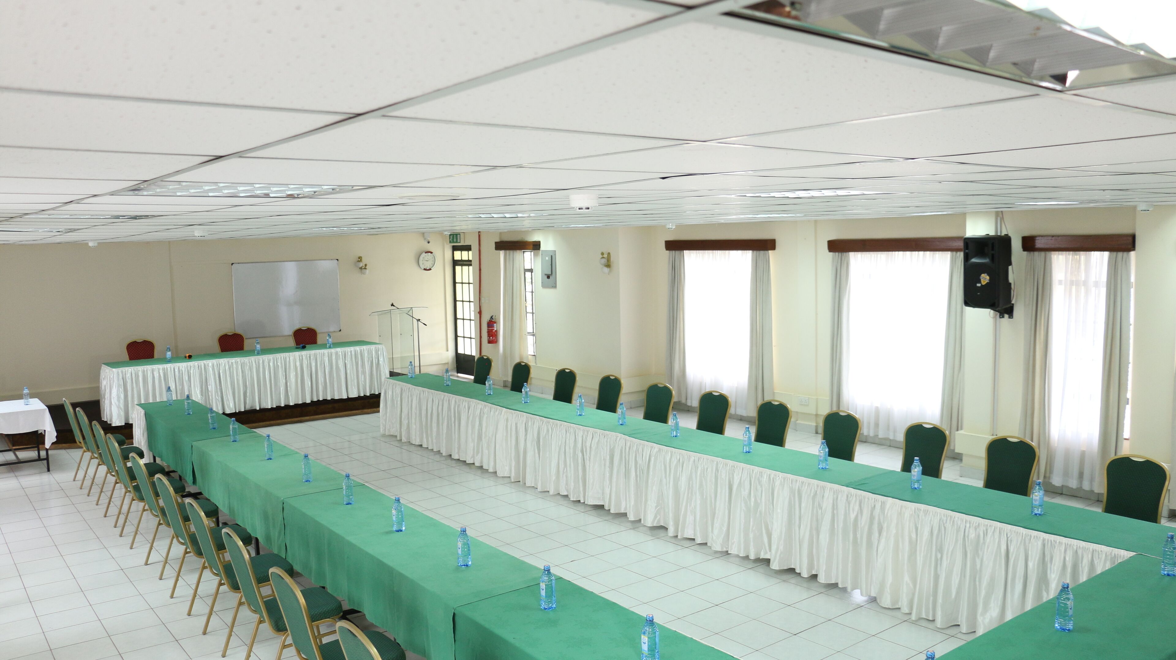 A conference room with long tables, chairs, and water bottles.