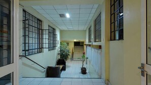 A hallway with tiled floors, large windows, and a staircase leading to an upper floor. - LMS Guest House (Nairobi)