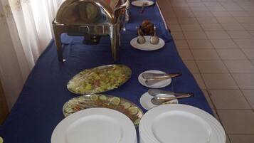 A buffet setup with multiple serving stations, including a hot food station and a salad bar.