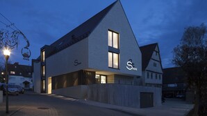 A modern building with a prominent 'Szweil' sign, featuring a large window and a sloped roof. - Hotel Schwanen Köngen (Kongen)