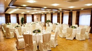 A banquet hall with round tables, white chairs, and floral centerpieces. - Hotel Schwanen Köngen (Kongen)