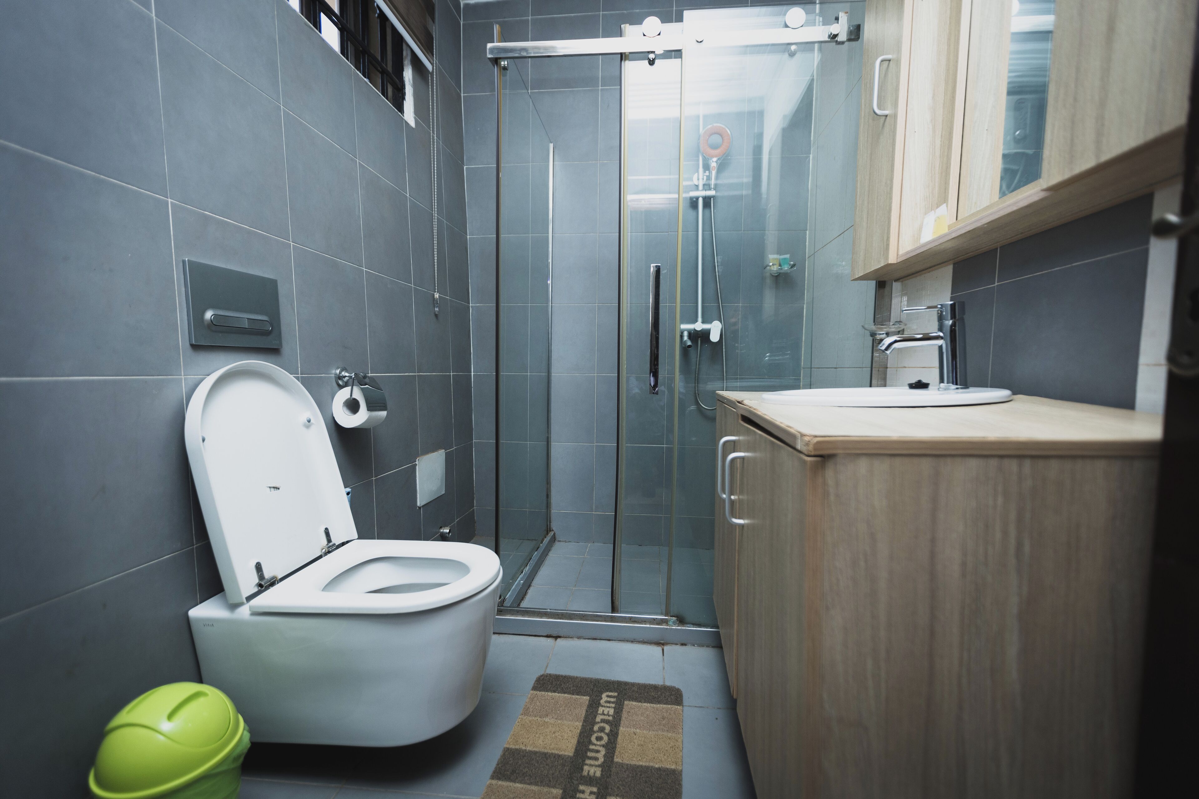 A modern bathroom with a toilet, shower, and sink.