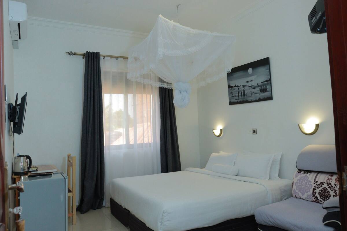 A bedroom with a bed, bedside table, and a chair.