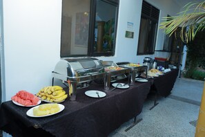 A buffet table with various food items and utensils. - Mowicribs Hotel & Spa (Entebbe)