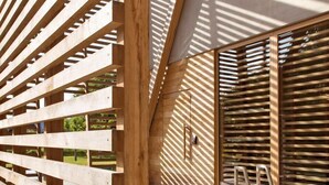 A modern architectural design with wooden slats and a pool area.