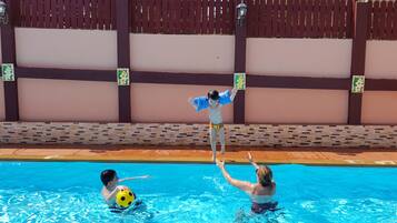 Enjoy a refreshing swim in our pool surrounded by a decorative wall with a unique pattern.