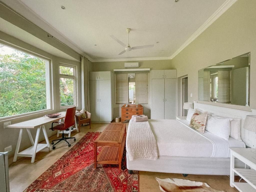 Un dormitorio con cama, escritorio, silla, cómoda y ventana.