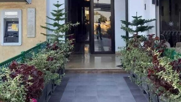 Entrada de hotel con diseño moderno, que incluye un panel de vidrio decorativo y un letrero sobre la puerta.