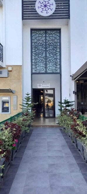 A hotel entrance with a modern design, including a decorative glass panel and a sign above the door.