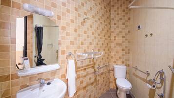 Baño con lavamanos, espejo, inodoro y ducha.