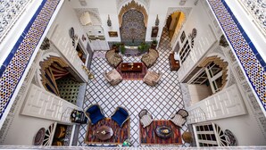 Un interior ornamentado con detalles intrincados en azulejos, un arco central y mobiliario tradicional.