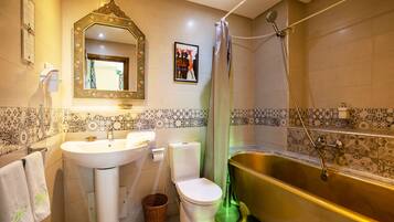 Een badkamer met wastafel, toilet en bad.