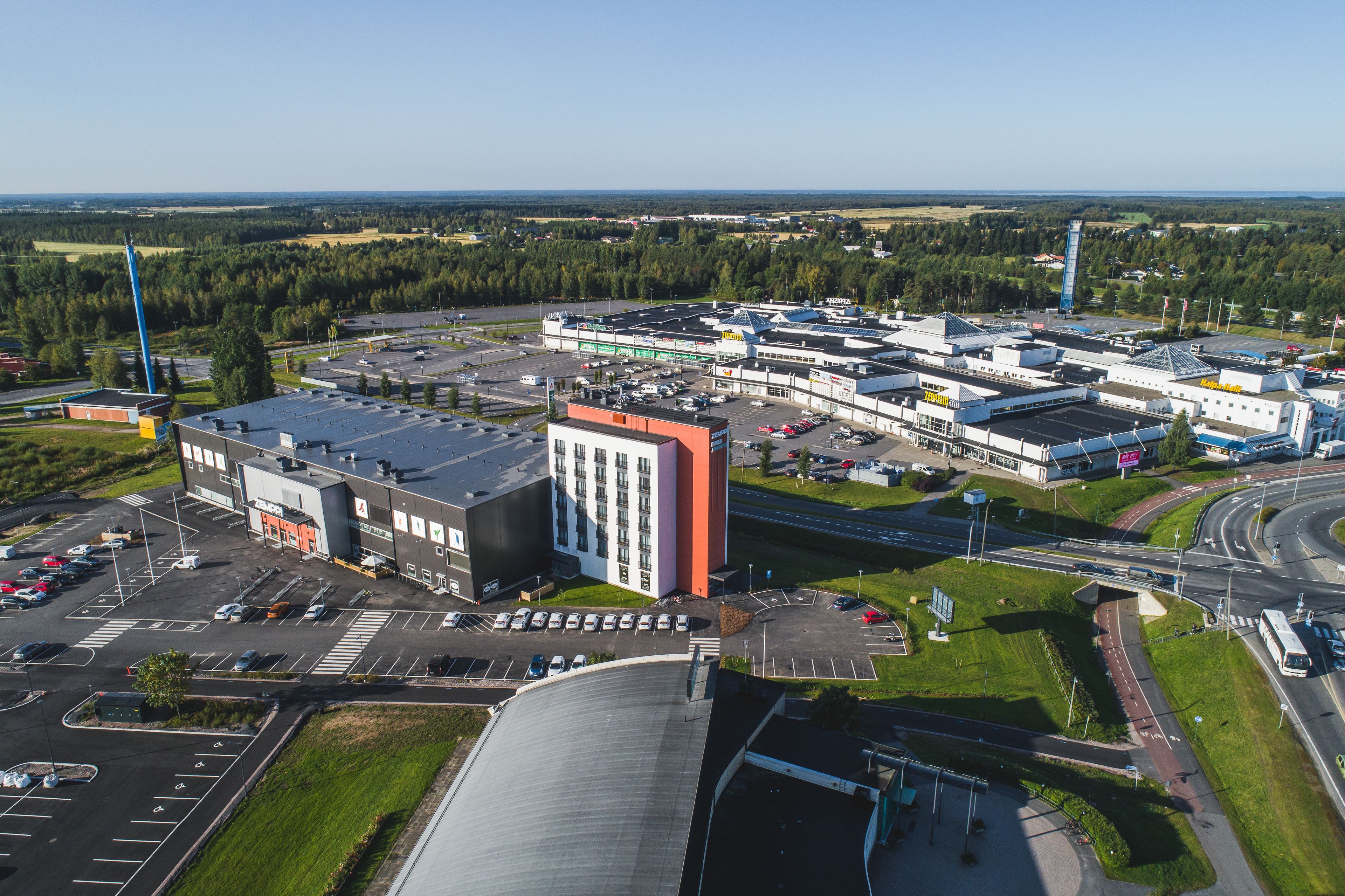 Une zone industrielle comprenant plusieurs bâtiments, des parkings et un échangeur autoroutier.