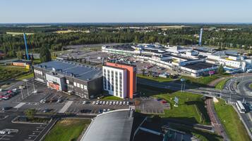 Une zone industrielle comprenant plusieurs bâtiments, des parkings et un échangeur autoroutier.