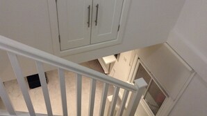 A white staircase with a handrail leading to a landing. - Central Windsor Apartments (Windsor)