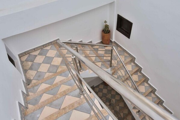 A staircase with a checkered tile pattern and metal handrails.