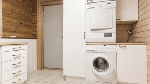 Ein kleiner Hauswirtschaftsraum mit Waschmaschine, Trockner und einem Schrank mit Schubladen.