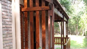 A wooden porch with a brick wall and a gravel path leading to it. - Merlión (Mar de Las Pampas)