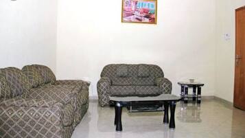 A living room with patterned sofas, a coffee table, and a small side table.
