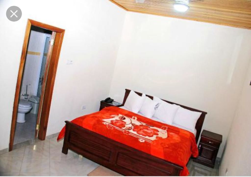 Un dormitorio con una cama de madera, una mesita de noche y una pequeña tocador.