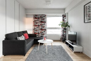 Apartamento superior, 1 habitación, vistas parciales al mar | Sala de estar | Una televisión de pantalla plana
