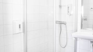 Une salle de bain moderne avec une douche à parois de verre, un lavabo blanc et des toilettes.