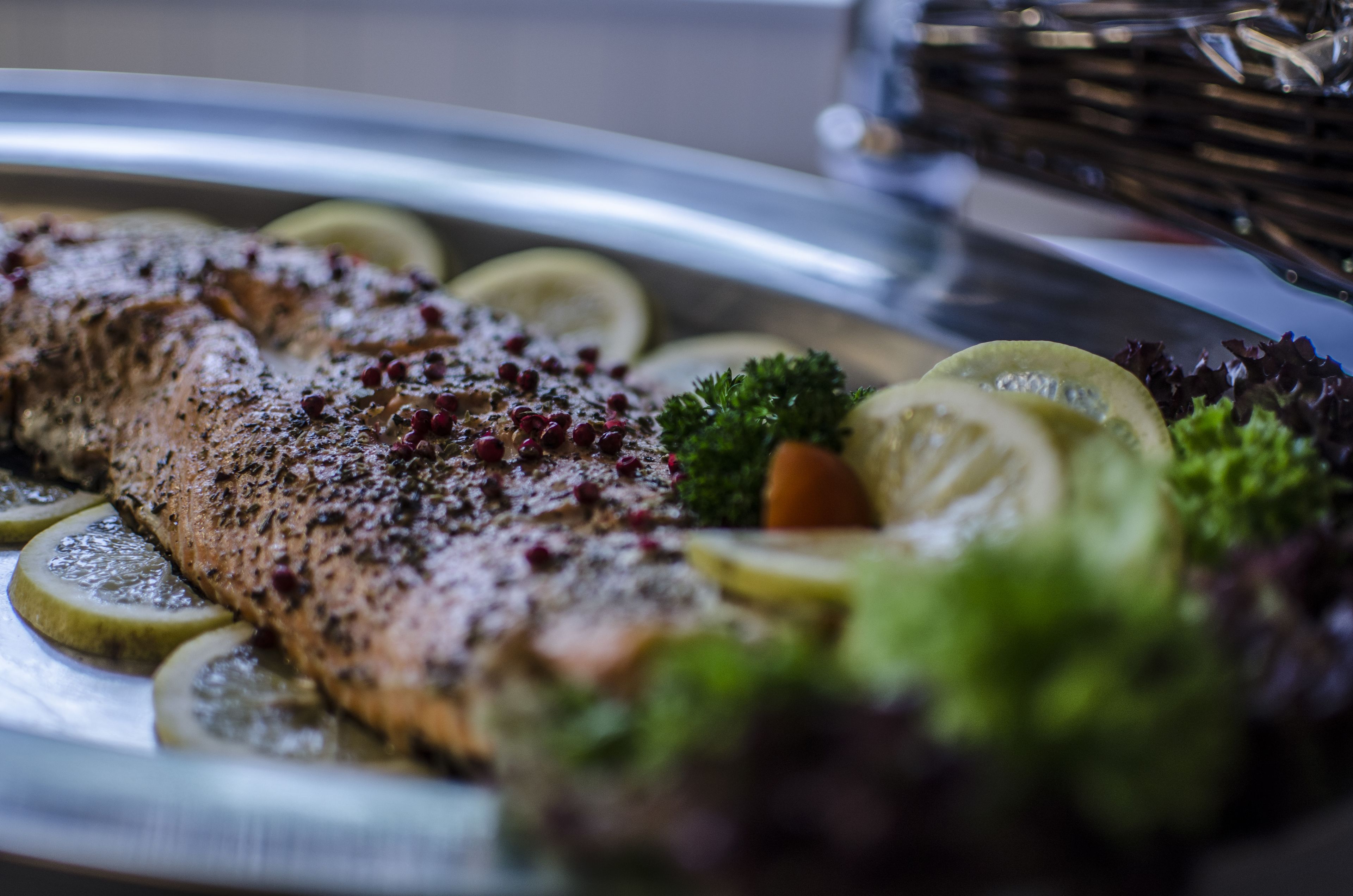 A salmon fillet with lemon slices and herbs on a plate.